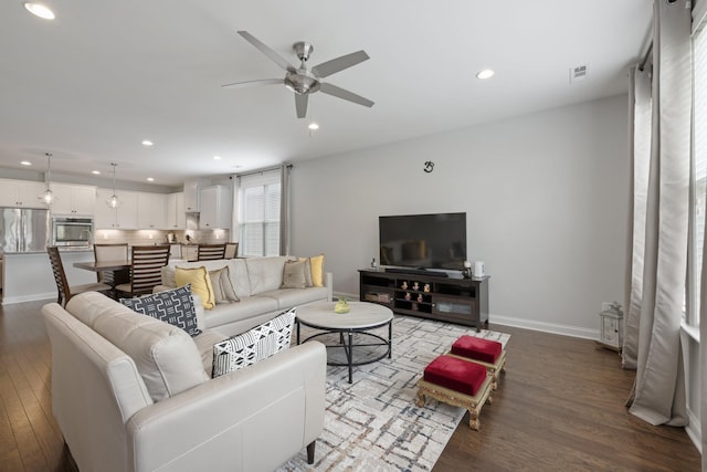 living area featuring a ceiling fan, recessed lighting, baseboards, and wood finished floors