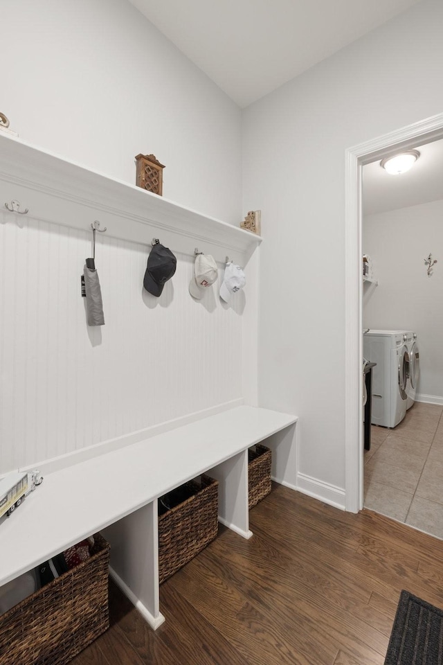 mudroom featuring baseboards, wood finished floors, and washing machine and clothes dryer