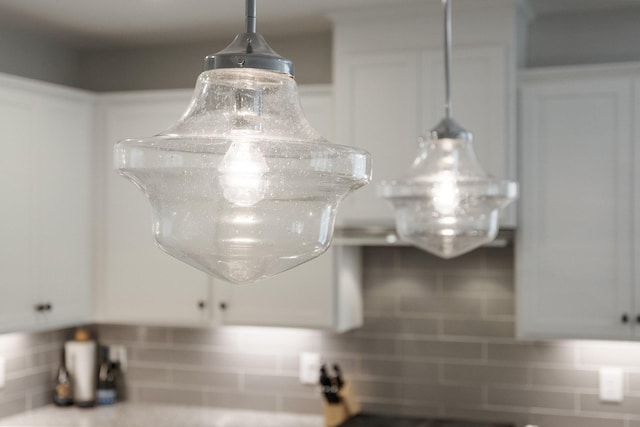 room details with light countertops, white cabinets, and decorative light fixtures