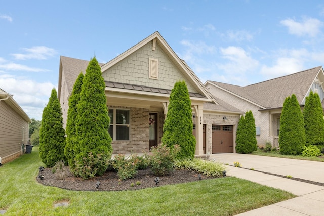 view of front of home with an attached garage, brick siding, concrete driveway, a front lawn, and a standing seam roof