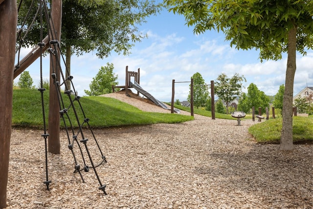 view of home's community featuring playground community and a lawn