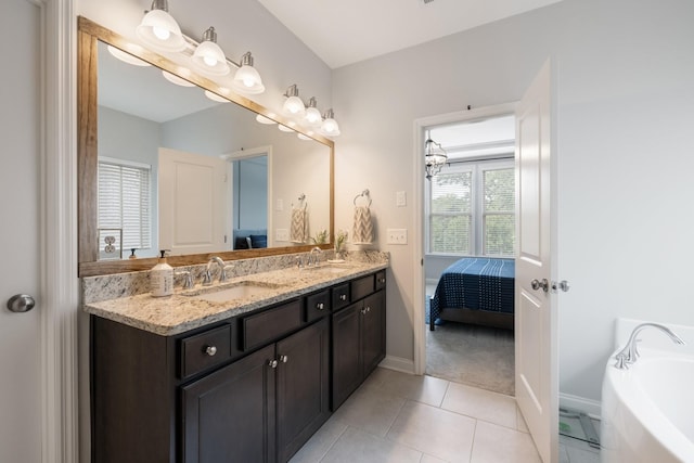 ensuite bathroom with double vanity, a sink, connected bathroom, a tub, and tile patterned floors