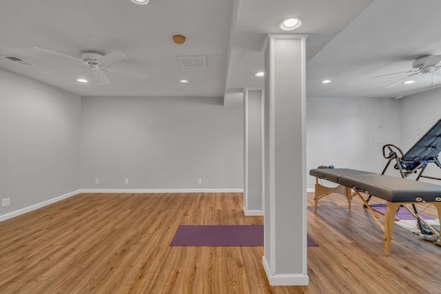 exercise area featuring light wood finished floors, baseboards, visible vents, and a ceiling fan