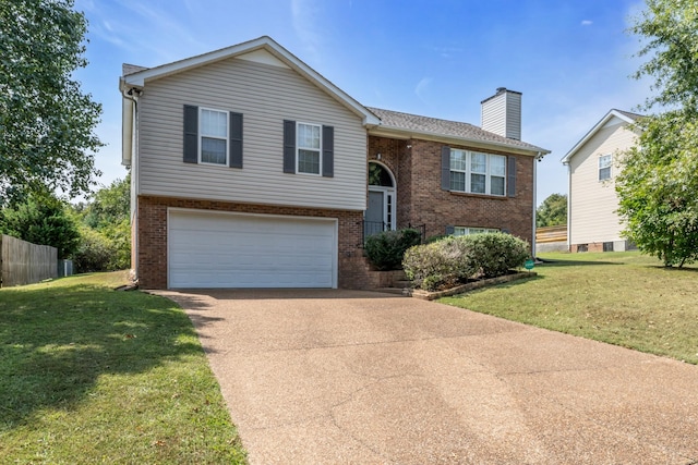 bi-level home featuring concrete driveway, brick siding, a front lawn, and a chimney