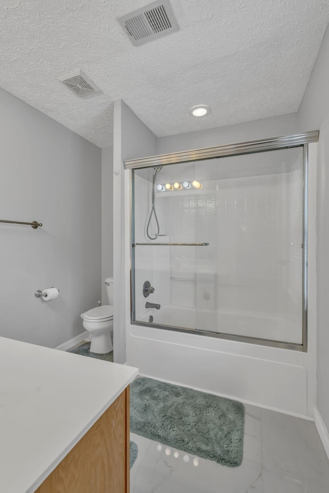 bathroom featuring a textured ceiling, combined bath / shower with glass door, vanity, and visible vents