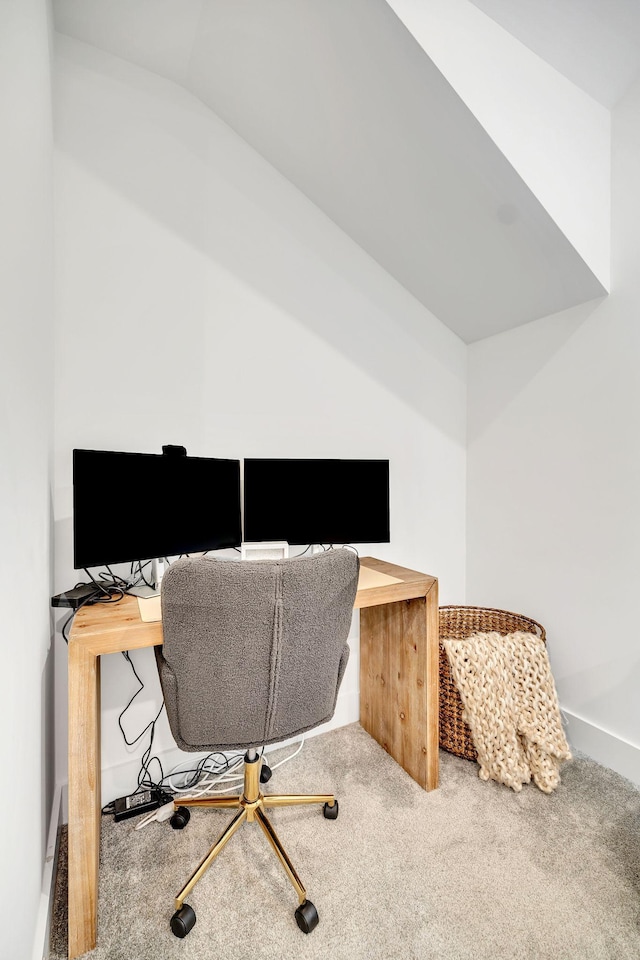 carpeted office featuring lofted ceiling