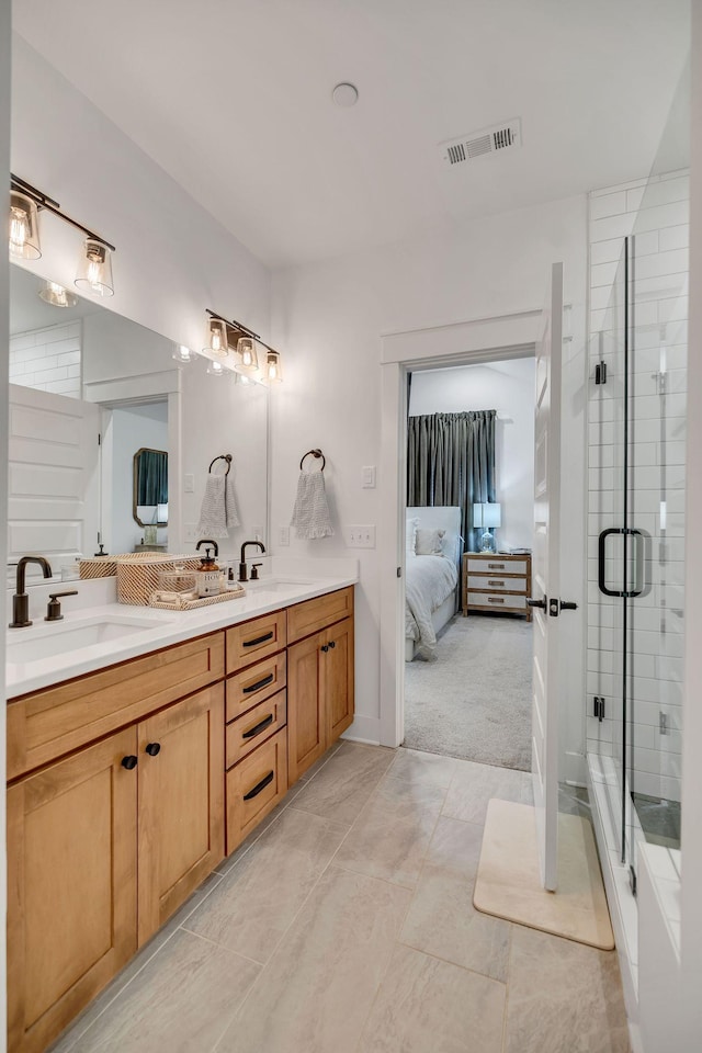 bathroom featuring double vanity, a stall shower, a sink, and visible vents