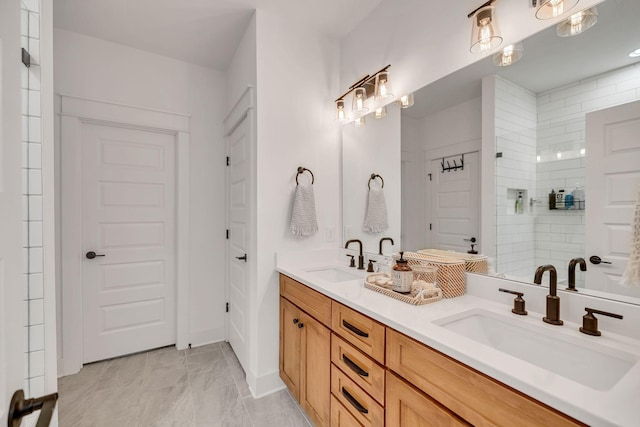 bathroom with double vanity, a sink, marble finish floor, and a walk in shower