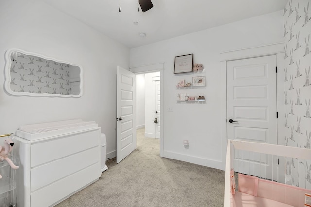 bedroom featuring light carpet, a ceiling fan, and baseboards