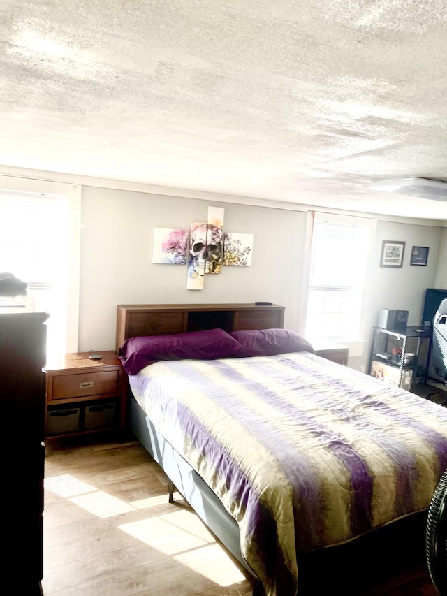 bedroom featuring a textured ceiling and wood finished floors