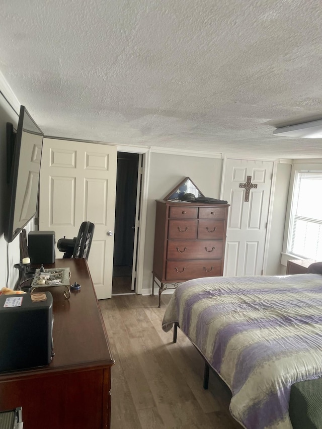 bedroom featuring a textured ceiling and wood finished floors