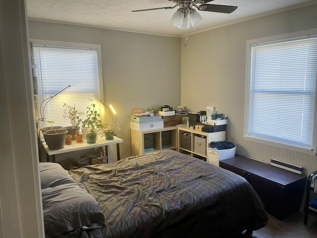 bedroom with ornamental molding, multiple windows, and a ceiling fan