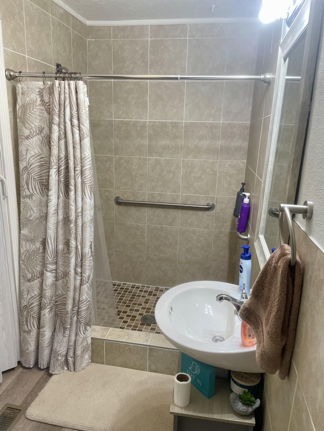 bathroom featuring a sink, a shower stall, and visible vents