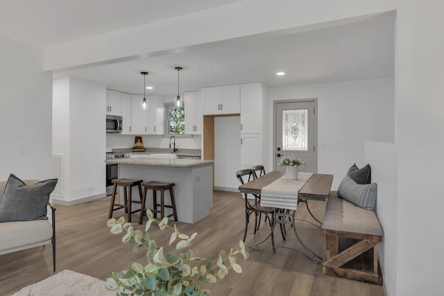 dining area with light wood finished floors, baseboards, and recessed lighting