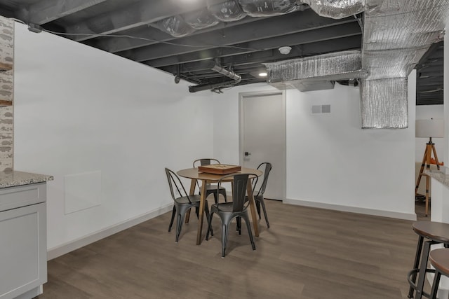 dining space with baseboards, visible vents, and wood finished floors