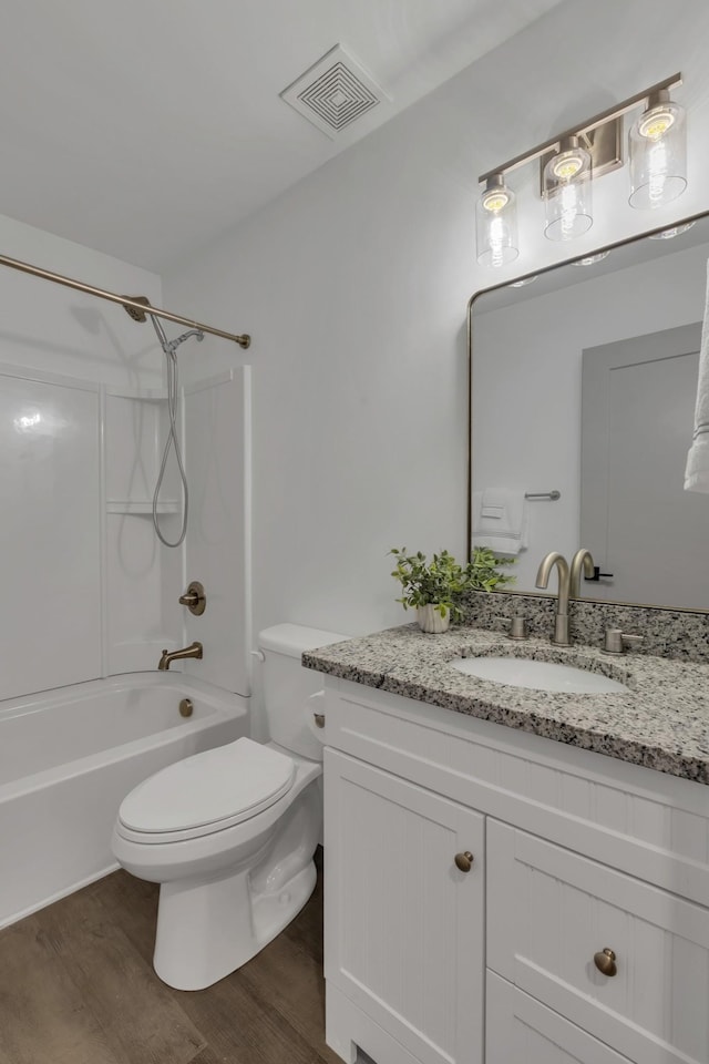 full bath with visible vents, shower / bathing tub combination, toilet, vanity, and wood finished floors