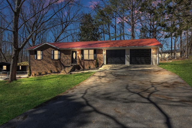 ranch-style house featuring a garage, driveway, brick siding, and a front yard