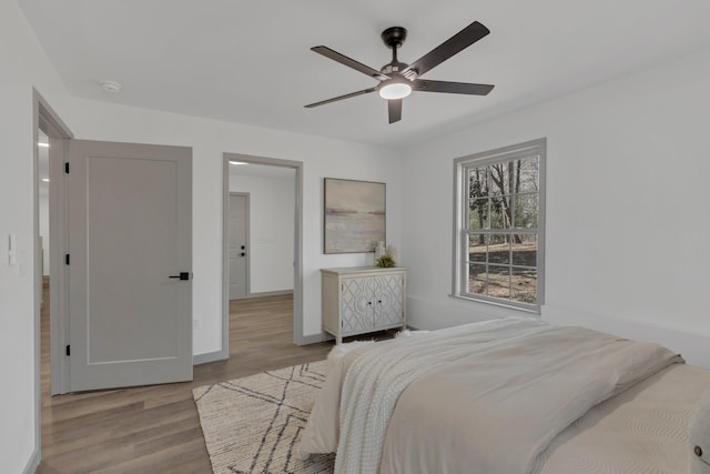 bedroom featuring wood finished floors, a ceiling fan, and baseboards