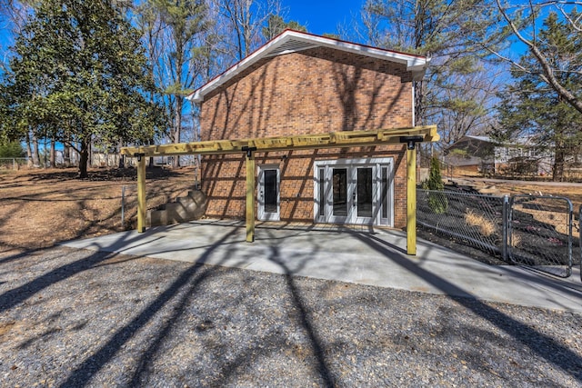 view of outbuilding featuring french doors and fence