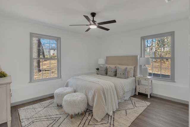 bedroom with a ceiling fan, baseboards, and wood finished floors