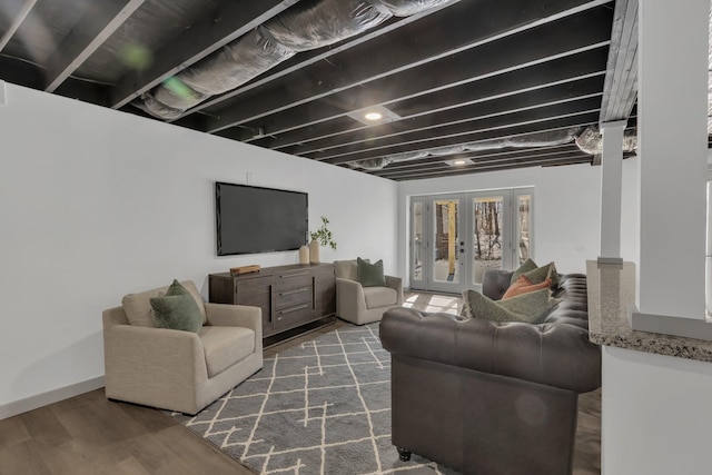 living area with baseboards, wood finished floors, and french doors