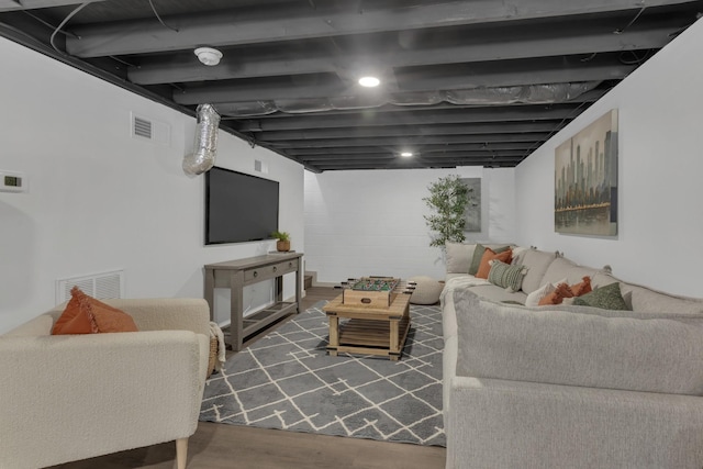 living area with dark wood-style flooring and visible vents