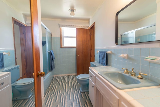 full bath featuring a wainscoted wall, vanity, toilet, and tile walls