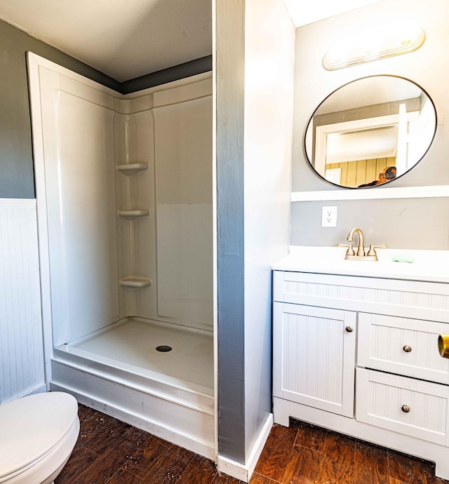 full bath with toilet, a shower, wood finished floors, and vanity