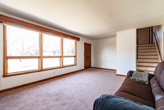 unfurnished living room featuring carpet, stairway, and baseboards