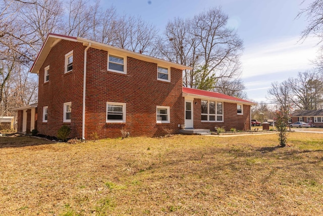 view of front of property with a front lawn and brick siding