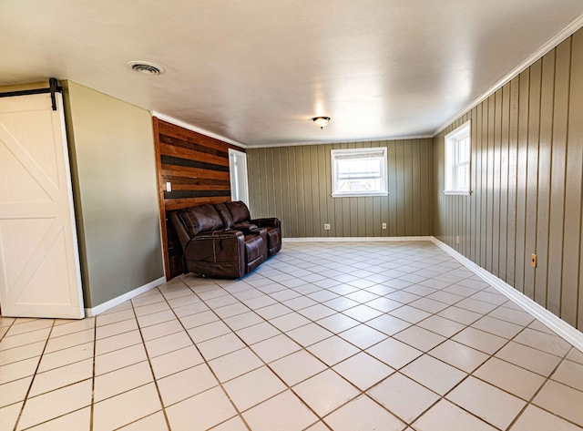 sitting room with visible vents, baseboards, and a barn door