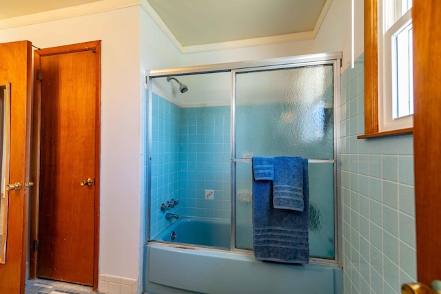 bathroom with shower / bath combination with glass door and tile walls