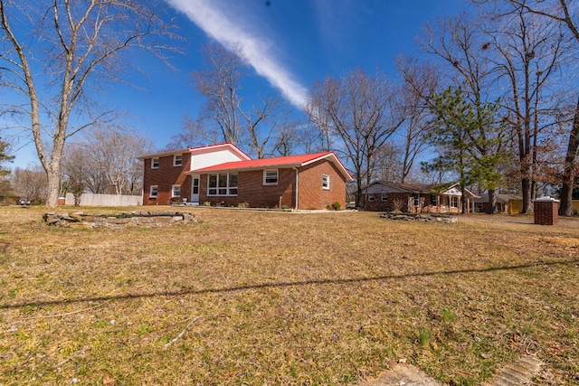 back of property featuring brick siding and a lawn