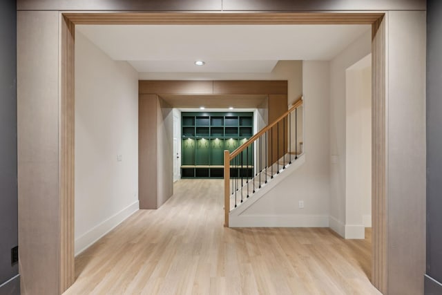 hallway featuring stairs, wood finished floors, and baseboards