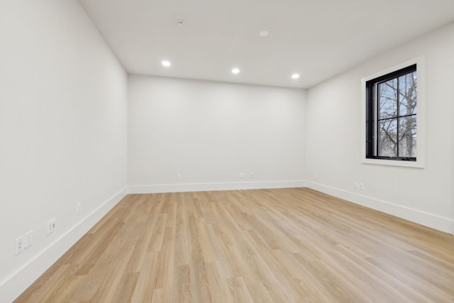 unfurnished room with light wood finished floors, recessed lighting, and baseboards