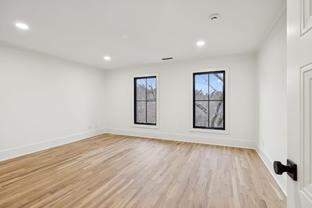 spare room with ornamental molding, light wood finished floors, recessed lighting, and baseboards