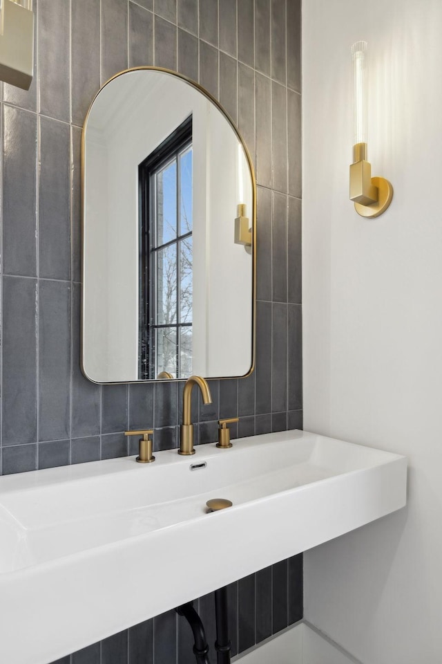 bathroom featuring tasteful backsplash, a sink, and tile walls