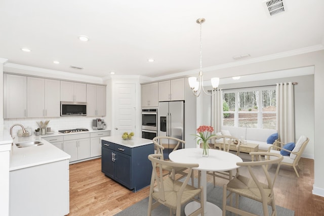 kitchen with light wood-style flooring, a sink, visible vents, appliances with stainless steel finishes, and backsplash