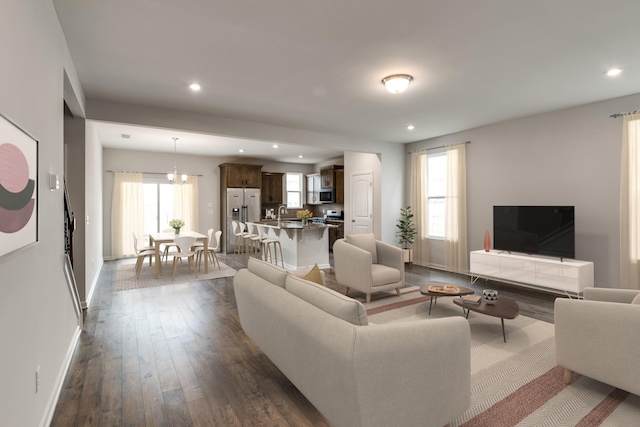 living area featuring baseboards, dark wood-type flooring, recessed lighting, and a healthy amount of sunlight