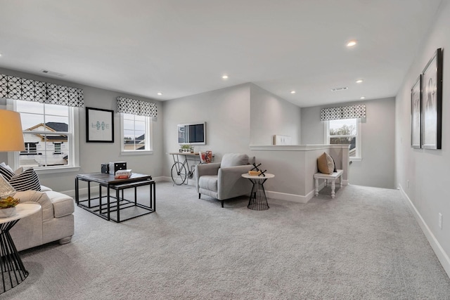 carpeted living area with recessed lighting, visible vents, and baseboards