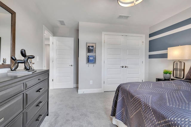 bedroom with a closet, light carpet, visible vents, and baseboards