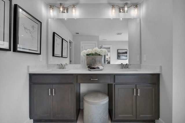 full bath featuring double vanity, visible vents, and a sink