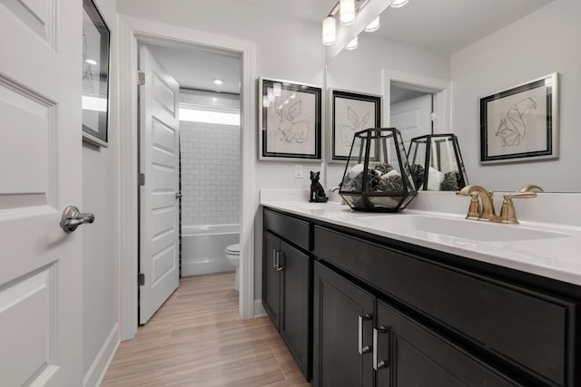 bathroom with tub / shower combination, a sink, toilet, and double vanity