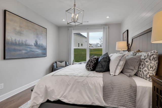 bedroom with a notable chandelier, recessed lighting, wood finished floors, visible vents, and baseboards