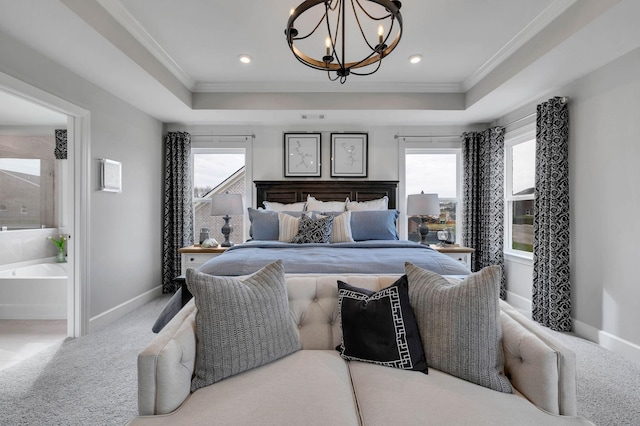 bedroom with a tray ceiling, multiple windows, and carpet