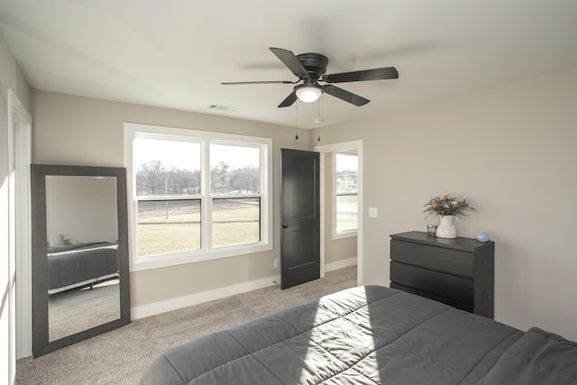 carpeted bedroom with ceiling fan, visible vents, and baseboards