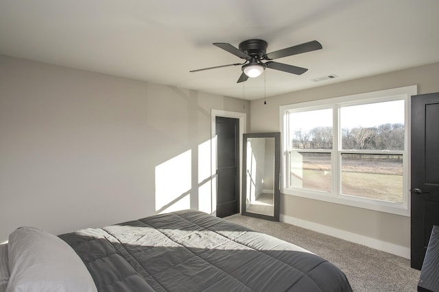 carpeted bedroom featuring visible vents, baseboards, and a ceiling fan