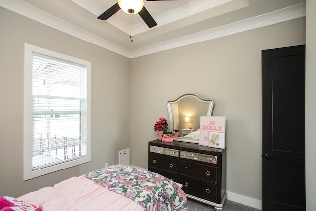 carpeted bedroom featuring a tray ceiling, ornamental molding, and baseboards