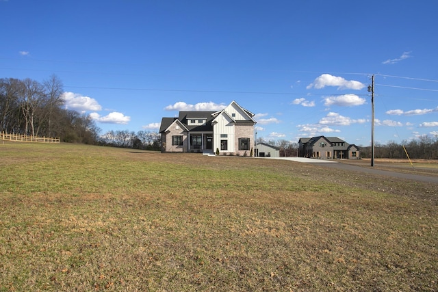 traditional-style house featuring a front lawn and board and batten siding