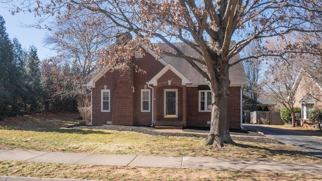 view of front of property featuring a chimney, a front yard, fence, and brick siding